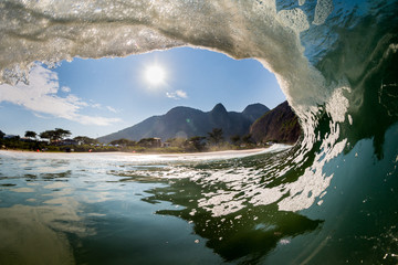 water shot from inside a barrel wave in brazil, with a view of mountains