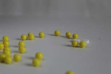 medicine pharmacy on a white background are scattered yellow round vitamins tablets with a place to insert text