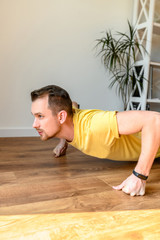 A young guy is training, he push ups
