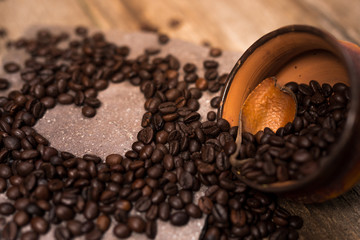 Old rustic wood table, roasted coffee beans and cup of coffee