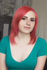 Portrait of a young woman with red hair and green dress with blue eyes