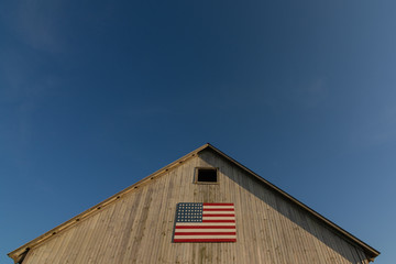 Old wooden barn with american flag. © Nicola