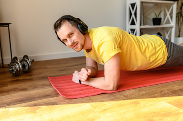 Young active guy doing abs workout at home