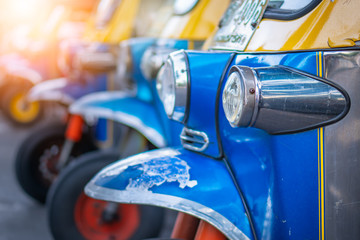 Obraz premium Tło kolorowy niebieski żółty tuk tuk tradycyjne lokalne taksówki dla turystów z miejsca na kopię. Zamknięcie miasta koronawirusa kwarantanna turystyka dystansująca społecznie pusta w bangkoku bez pasażera podróżującego