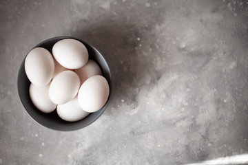 Plate filled with eggs.More than four eggs.Photo taken on concrete background.
Gray plate and chicken eggs.The sun's rays fall into the frame.