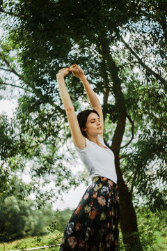 Young woman is stretched in forest