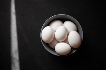 Plate filled with eggs.More than four eggs.Photo taken on concrete background.
Gray plate and chicken eggs.The sun's rays fall into the frame.