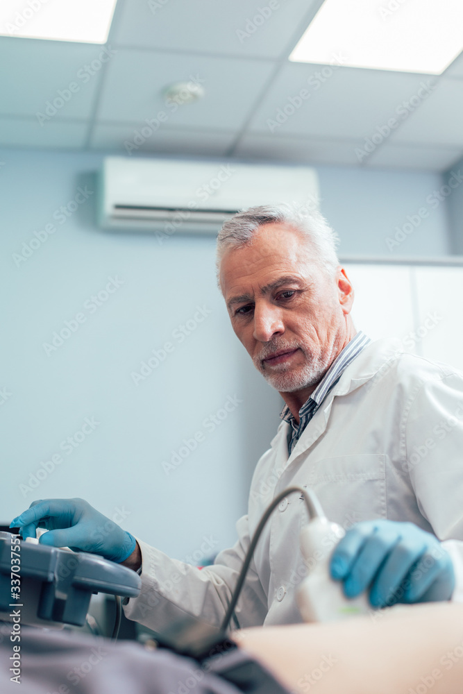 Wall mural doctor in clinic working with modern ultrasound equipment