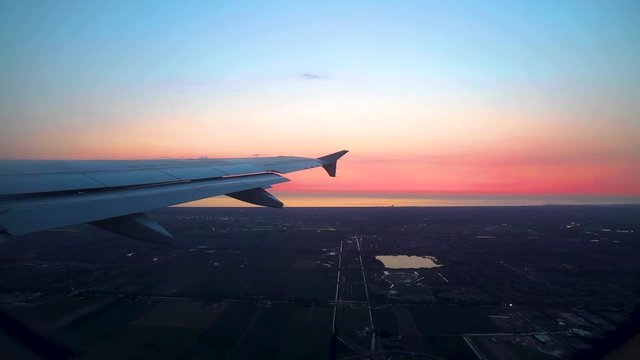 View of Airplane Wing From Window Landing in Italy During Sunset