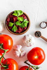 Homemade tomato sause near ingredients - garlic, spices - on white background top-down