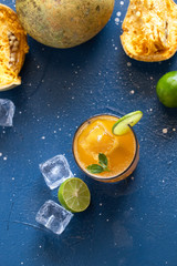 exotic fruit juice from Bel fruit or wooden Apple called in India Bel Ka Sharbat. cold fruit drink with ice on a blue background. natural detox. vitamins for immunity
