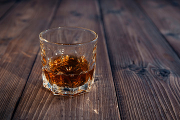 Glass of whiskey on an old wooden table
