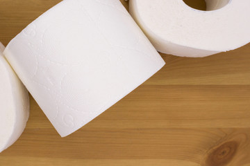 White toilet paper, rolled,  on wooden  background, copy space.