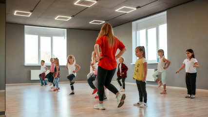 Dance for kids. Group of little boys and girls dancing while having choreography class in the dance studio. Dance teacher and children