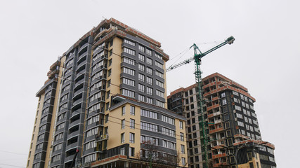Fototapeta premium Construction site. High-rise multi-storey buildings under construction. Tower cranes near buildings.