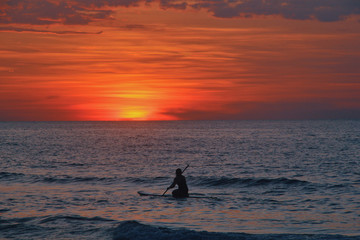 Fototapeta premium silhouette of a surfer at sunset