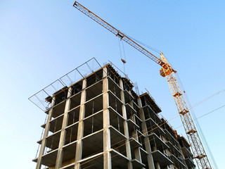 Self-erecting crane near the building under construction. Construction site background.