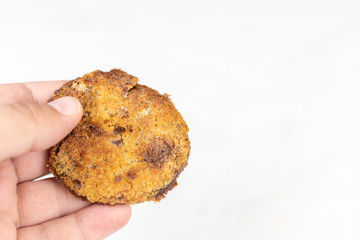 Homemade crisp biscuits cookies with chocolate in the hand above white background