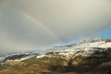 Image of snowy mountains with a rainbow.