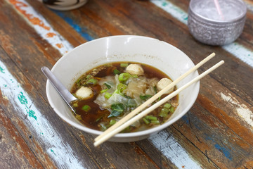 Bowl Of Rice noodles soup with meat ball in a bowl eating by chopsticks, Asian food, Thai style, Angle view