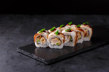 Sushi rolls with eel, cucumber, nori, cremette cheese, onion feathers, tempura shrimp sesame and...