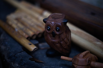 Handmade wooden owl whistle in dark brown color.