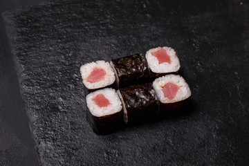 Close-up of maki sushi rolls with tuna on black background
