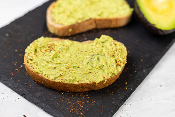 Avocado spread with grated chilly peppers on the sliced toasted bread