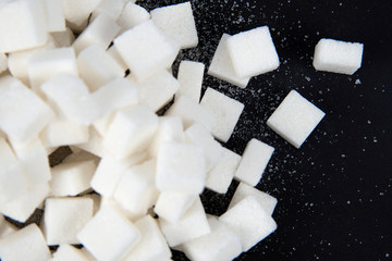 White sugar cubes isolated on black background