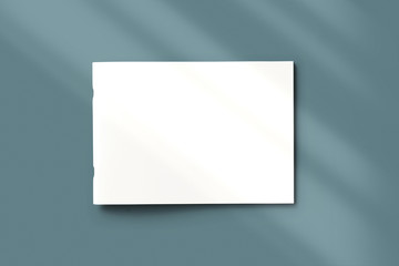 High view of blank closed landscape magazine brochure with shadow overlay from above on grey background as template for design presentation, branding, promotion etc.