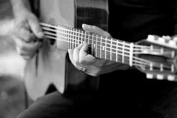 Dettaglio di una chitarra a corde suonata da due mani