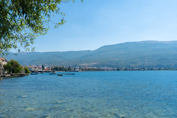 Beach with crystal clear water of Lake Ohrid in North Macedonia during hot summer day. August 2019