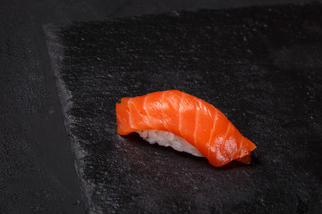 Salmon sushi on black background
