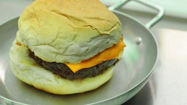 Close up of cheeseburger served on a steel pan