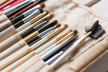 Makeup, beauty and cosmetics concept - Set of make-up brushes in a light case.