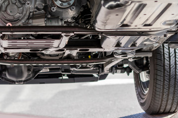 Unterboden eines Geländewagen , SUV oder Geländefahrzeugs zeigt automobile Ingenieurskunst im Detail mit Radaufhängung, Auspuff, Katalysator und Prüfung und Wartung in der KFZ-Werkstatt