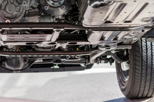 Unterboden eines Gel&auml;ndewagen , SUV oder Gel&auml;ndefahrzeugs zeigt automobile Ingenieurskunst im Detail mit Radaufh&auml;ngung, Auspuff, Katalysator und Pr&uuml;fung und Wartung in der KFZ-Werkstatt