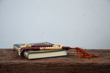 Quran - holy book of Muslims religion, Concept: open book holy prayers for god,
 Friday In the month of Ramadan  religion Islamic worshiping faith and learn koran and rosary put on wooden  boards 