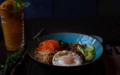 Korean dish bibimbap  - mixed rice with meat and assorted vegetables on dark background