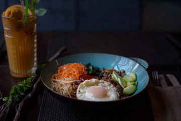 Korean dish bibimbap  - mixed rice with meat and assorted vegetables on dark background