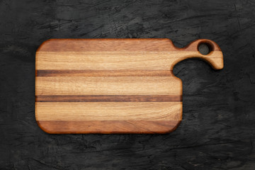Wooden board, for cutting food in the kitchen, on black background