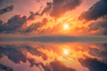 Colorful sunset with dramatic sky background over sea.