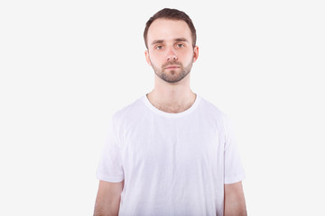 Fototapeta premium Unshaven man in casual t-shirt looks sad at camera. Isolated, white backgroung