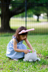 Little toddler girl with bunny ears. Easter egg hunt. - 337057776