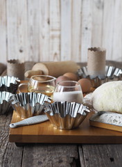 Dough for Easter cakes, croissants, or bread on the background of molds for Easter cakes and ingredients for kneading dough.