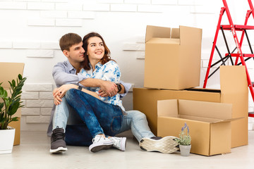 Fototapeta na wymiar Smiling couple leaning on boxes in new home