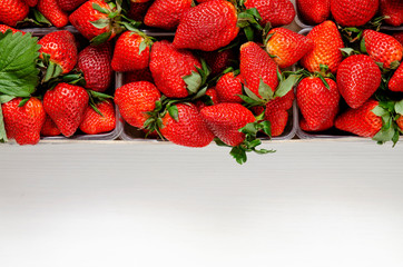 Strawberries in baskets in a wooden box top view . The concept of a healthy diet, vegetarian. Fresh ripe strawberries in a box. A group of boxes with fresh strawberries. Close-up.
