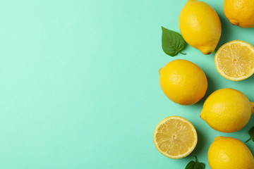 Fresh lemons on mint background, top view. Ripe fruit