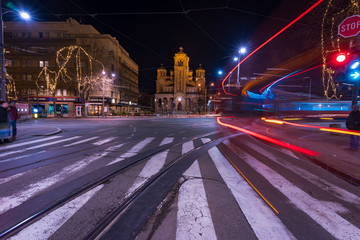 Fototapeta na wymiar Saint Mark's church at night and light trails from passing trams and buses in Belgrade