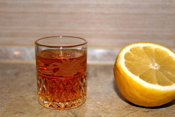 Alcoholic drink poured into a transparent glass in combination with lemon